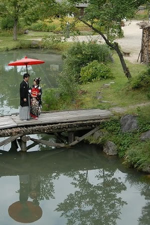 白川郷の池に移る新郎新婦のウェディングフォト