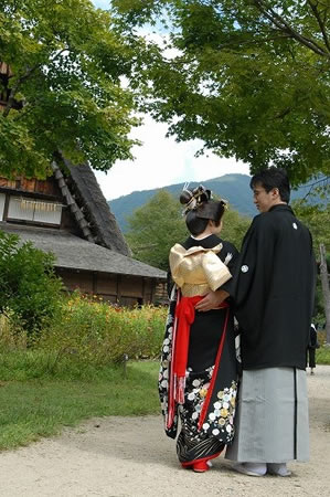 白川郷の合掌造りに向かう新郎新婦