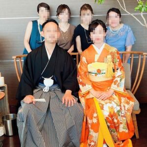 オレンジ色のリメイク打掛を着た花嫁と花婿とご友人