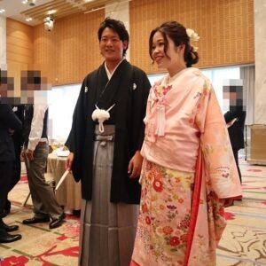 桃色のリメイク打掛を着た花嫁と花婿
