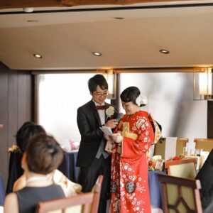 オレンジ色のリメイク引き振袖を着た花嫁と花婿