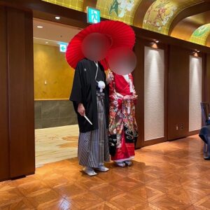 赤色のリメイク打掛を着た花嫁と花婿