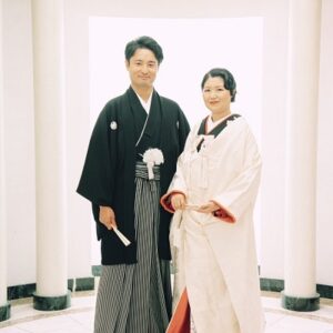 黒色のリメイク引き振袖を掛下で着用し白無垢を羽織った花嫁と花婿