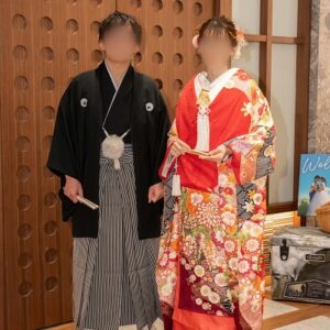 赤色のリメイク打掛を着た花嫁と花婿