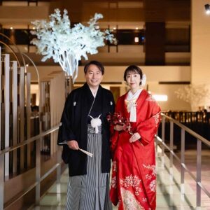 赤色のリメイク打掛を着た花嫁と花婿