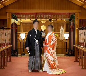 赤色のリメイク打掛を着た花嫁と花婿